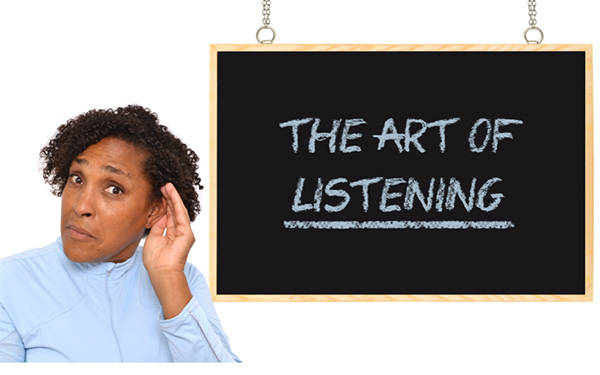 A woman cupping her ear next to a chalkboard that says "The Art of Listening"